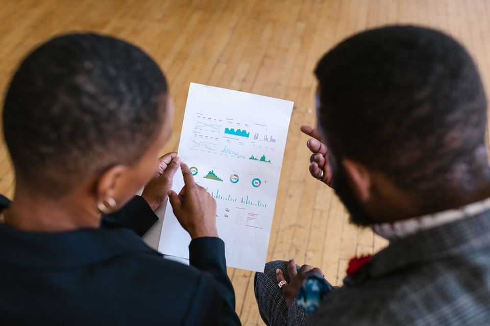 Two colleagues looking over a printed page of charts together