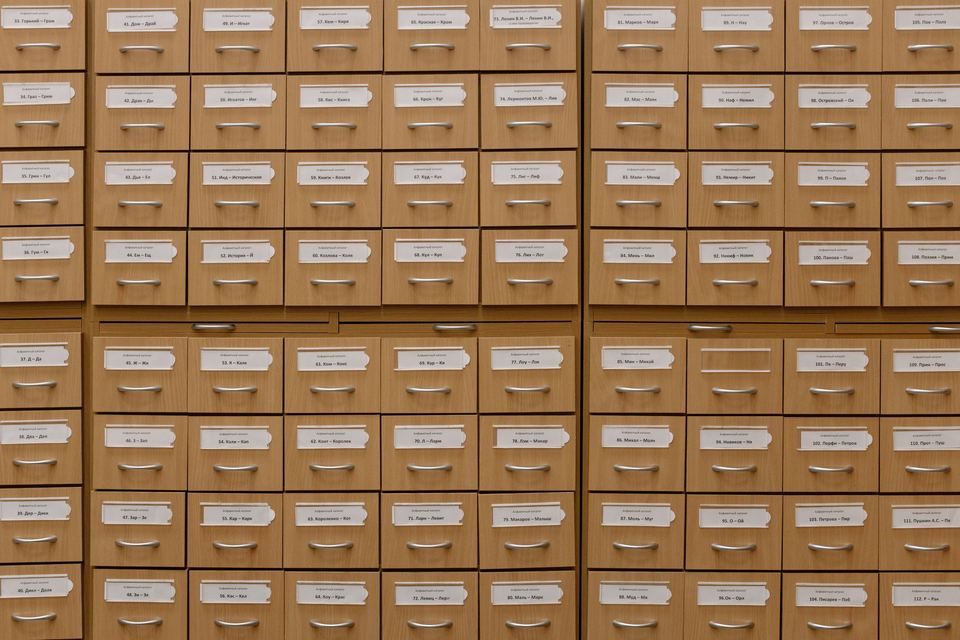 Rows of labelled wooden filing drawers covering a wall