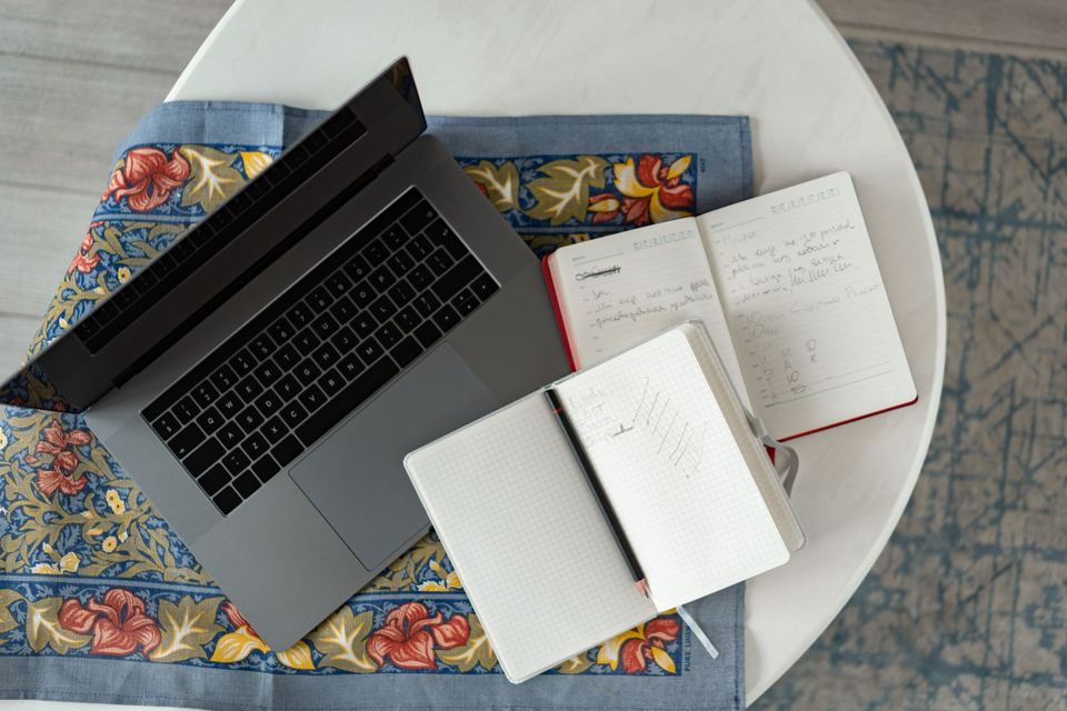 A laptop and notebook on a desk