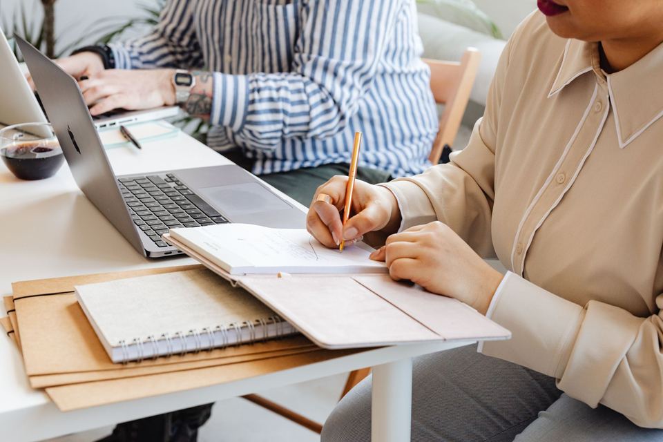 Two people planning an AI project at a desk with a laptop