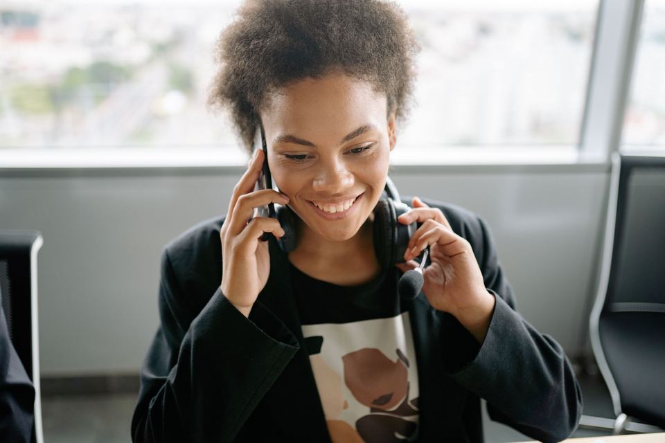 Someone answering customer enquiries at a desk wearing a headset