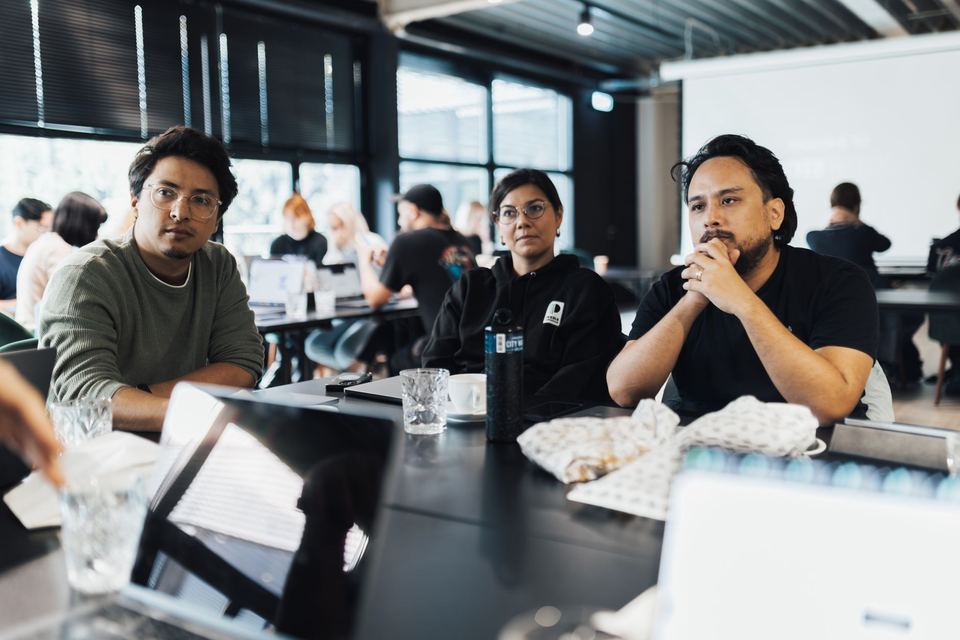 A small group working through AI training on laptops